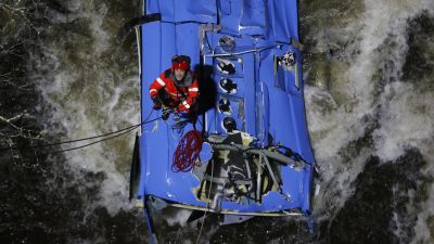 Los bomberos trabajan en el rescate de víctimas del autobús que se precipitó al río Lérez. (EFE/Lavandeira jr.)