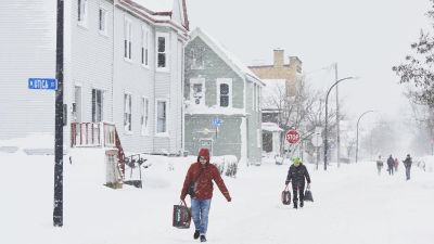 Los ciudadanos trasladan víveres a lo largo de una avenida cubierta de nieve en West Buffalo , Nueva York. / EFE.
