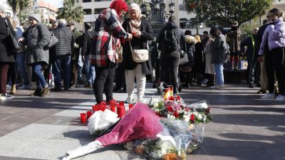 Dos mujeres colocan una vela en el sitio donde asesinaron al sacristán Diego Valencia de la iglesia de la Palma en Algeciras (Cádiz) en la noche del miércoles./ EFE/A.Carrasco Ragel.