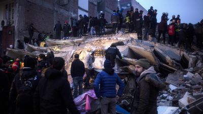 El personal de emergencia turco y multitud de personas tratan de ayudar a las víctimas en un edificio derrumbado después del terremoto en Diyarbakir. / EFE.