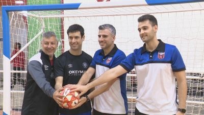 Entrenadores y jugadores de ambos equipos posan con el balón del partido.