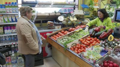 Una mujer comprando en un comercio de proximidad.