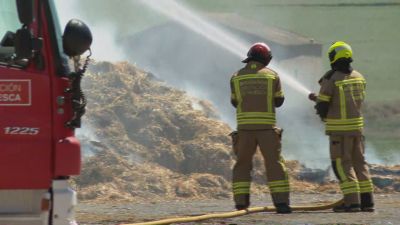 Bomberos de Huesca tratan de sofocar el incendio en un almacén de Lanaja