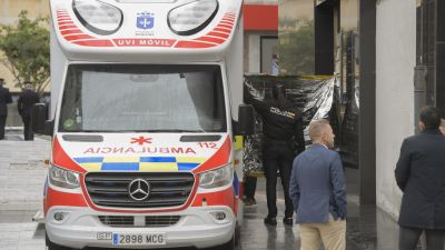Una ambulancia y agentes de Policía Nacional custodian el edificio donde se ha producido el suceso. / EFE