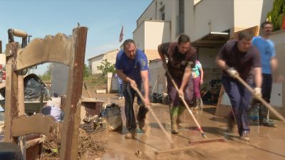 Vecinos de Pomar achican agua en la zona de las viviendas afectadas.