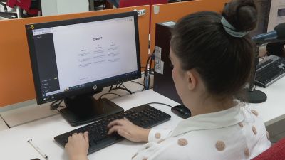 Una joven utiliza ChatGPT en su puesto de trabajo.