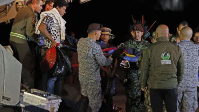 Los menores son descargados del avión que les ha trasladado a Bogotá. / Mauricio Dueñas EFE