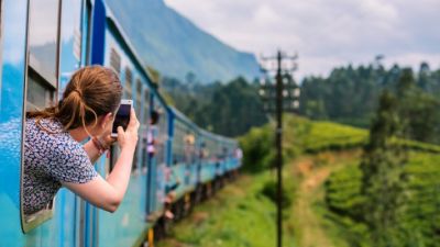Una joven tomando una foto desde un tren. / Canva.