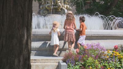Niños acercándose a una fuente para paliar el calor.