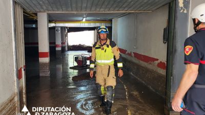 Bomberos de DPZ achicando agua de un garaje afectado por la tormenta del jueves. / DPZ