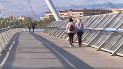 Personas paseando con viento en Zaragoza.