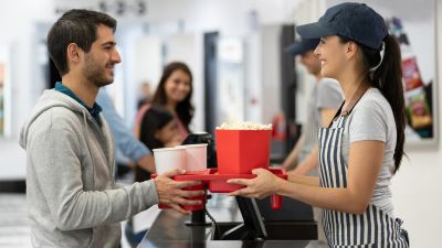 Un hombre compra palomitas antes de acceder a la sala de cine. / Canva