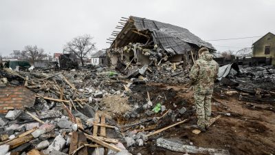 Un militar mira una casa dañada en un ataque con misiles rusos este lunes en Kiev (Ucrania). / EFE.