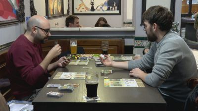 Dos amigos jugando a un juego de mesa en un bar zaragozano.