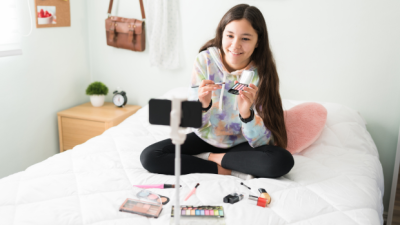 Una chica graba sus productos de maquillaje para subirlos a las redes sociales. / Canva