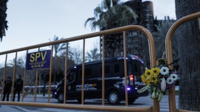 Un ramo de flores junto a la valla que corta el paso a los dos edificios calcinados. / EFE. Manuel Bruque