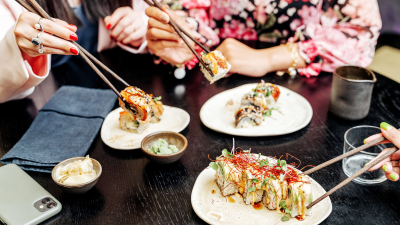 Tres personas comen sushi. / Canva