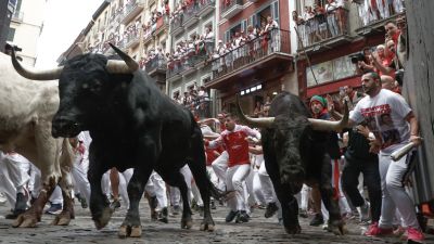 Mozos perseguidos por los toros de Victoriano del Río en el tercer encierro de los Sanfermines este martes, en Pamplona. / EFE