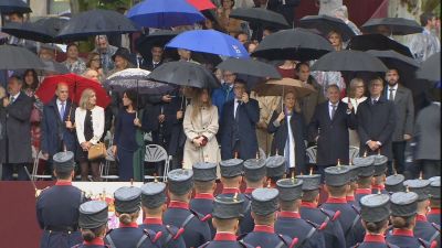 Las autoridades se protegen con paraguas de la intensa lluvia durante los actos militares. / FORTA