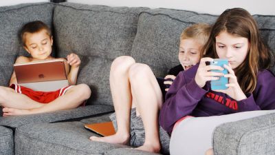 Niños utilizando teléfonos móviles y tabletas. / Canva