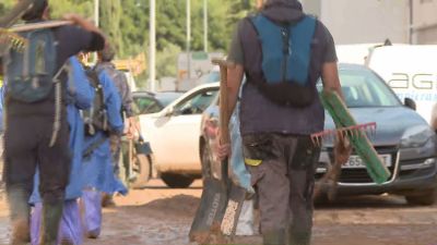 Varias voluntarios colaboran en la limpieza de una calle tras el paso de la DANA. / Aragón TV