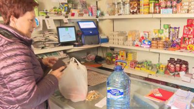 Una vecina de Samper de Calanda comprando agua mineral en un establecimiento. / Aragón TV