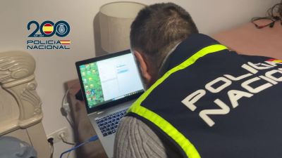 Un agente de la Policía Nacional investiga el ordenador de uno de los detenidos. / Policía Nacional