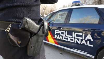 Un agente de la Policía Nacional junto al coche patrulla. / Europa Press