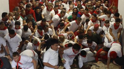 Varios corredores se amontonan en el acceso a la Plaza de Toros durante el segundo encierro de San Fermín. / EFE
