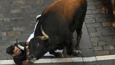 Un mozo es atropellado por un toro de la ganadería Álvaro Núñez en el tercer encierro de San Fermín 2025. / EFE