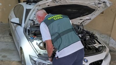 Un agente inspecciona uno de los vehículos localizados en los talleres clausurados.