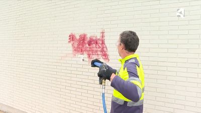 Operario eliminando grafitis de una fachada pública en Zaragoza