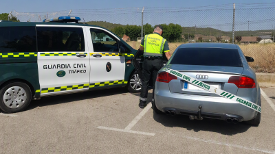 Agentes de la Guardia Civil custodian el vehículo del conductor infractor.