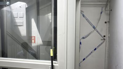 Puerta precintada por la policía en la calle Perines en Santander, donde ha sido asesinada una joven de 27 años.