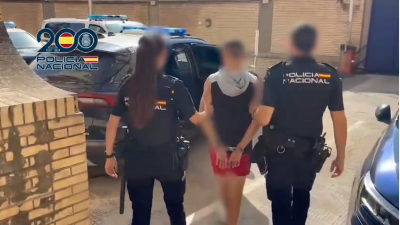 Dos agentes de la Policía Nacional escoltan al detenido.