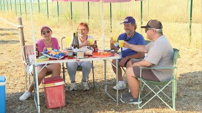Visitantes esperan merendando al momento del eclipse en Motorland.