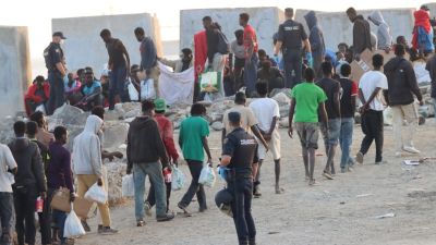 Policías proceden al desalojo de migrantes de la playa del Trampolín en Ceuta este jueves.