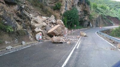 Una roca de grandes dimensiones obstaculiza buena parte de la calzada.