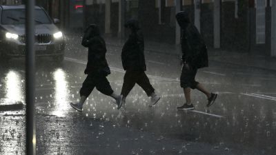 Varias personas caminan empapadas por una calle de Palma.