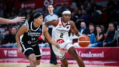 Aisha Sheppard peleando un balón con una jugadora lituana
